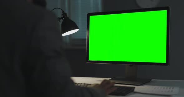 Man with Green Pc at Dark Office