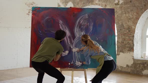 Passionate Couple Holding Smear Colorful Paints on Canvas Create Picture Together alt