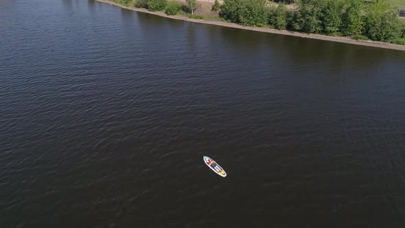 Aerial view of man lies on the paddle boarding (SUP) on pond 02 alt