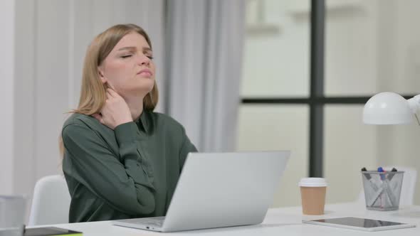 Young Woman Having Neck Pain While Typing on Laptop alt