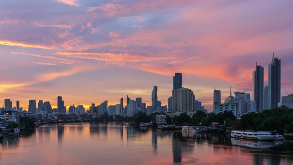 Dramatic sun rises over Chao Phraya River, Bangkok downtown city center, night to day - time lapse