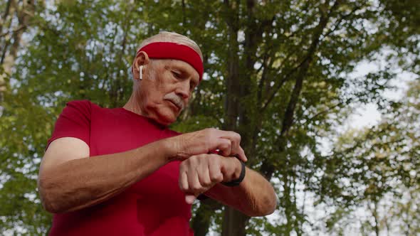 Senior Sport Runner Man Using Smart Watch Tapping Touchscreen, Tracking Result After Fitness Workout alt