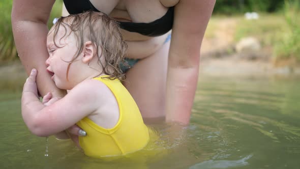 Little Funny Cute Blonde Girl Child Toddler in Yellow Bodysuit Crying Afraid of Learning Swim