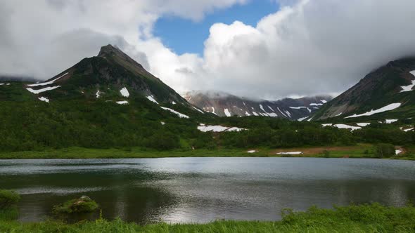 Rocky Mountains and Lake, Clouds Drifting Across Sky on Cloudy Weather