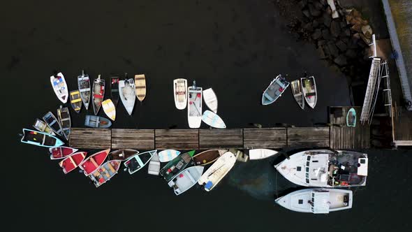 Drone shot of docks with small boats and lobster fishing boat leaking oil into the ocean HD 30p alt