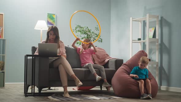 Young Woman Works at Home Little Children Distract Her Mother alt