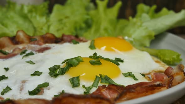 Fried Eggs with Bacon and Green Salad in a Bowl Rotate