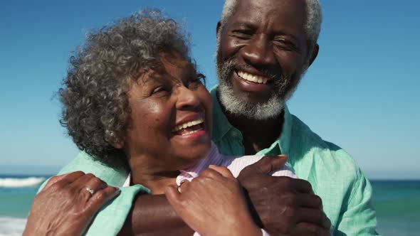 Senior couple hugging at the beach alt