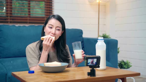 Asian women using camera streaming and recording vlog video about the benefit for broadcast online. alt