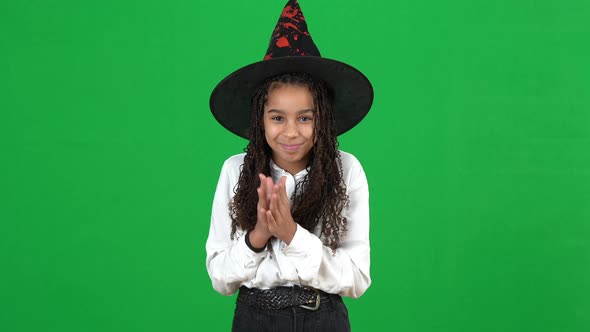 Smiling African American Teenage Girl in Halloween Witch Hat Posing at Chromakey Background alt