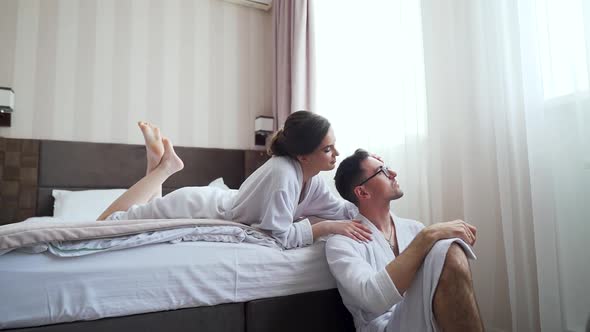 Young happy couple smiling having fun, resting lying on bed, husband and wife alt