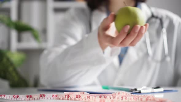 The Concept Of Plant Nutrition And Medicines. A Nutritionist Offers A Healthy Green Apple alt