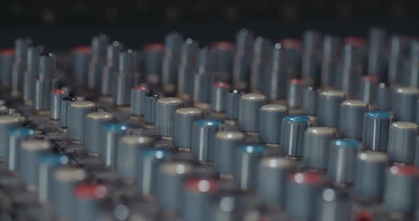 Sound engineer working in a recording studio with a sound console and microphones alt