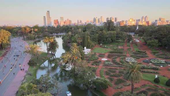 Aerial dolly in of Rosedal gardens and pond near Palermo Woods pedestrian street at golden hour, Bue alt