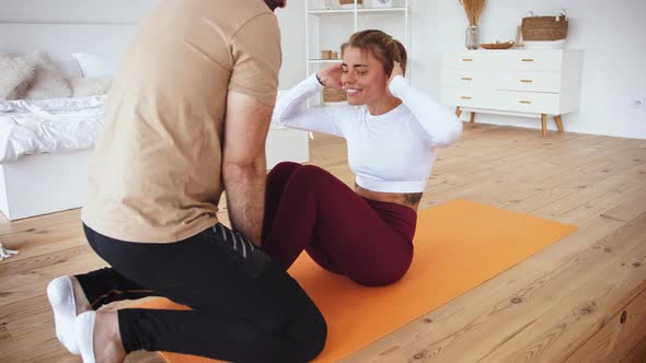 Young Couple is Doing Sport Excercises at Home in Cozy Bright Bedroom alt