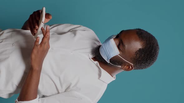 Vertical Video Male Entrepreneur Using Smartphone to Browse Internet alt