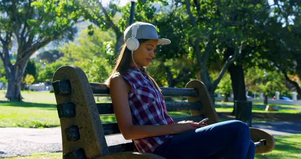 Woman listening music in park alt