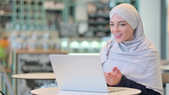 Modest Arab Woman Doing Video Call on Laptop  alt