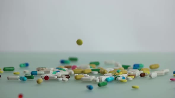 Colorful Medical Capsules Falling on the Table alt