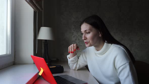 Woman Communicates By Video Call Conference Working at Home on a Laptop