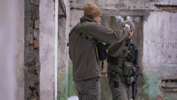 Two Serious Ukrainian Soldiers Bumping Fists Walking Away with Guns alt