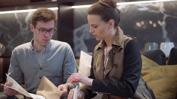 Positive Professional Interior Designer Helping Buyer Choosing Furniture Upholstery in Showroom alt