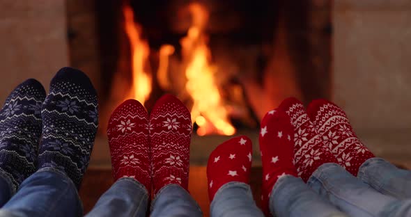 Happy family in Christmas socks near fireplace. Mother, father and children having fun together