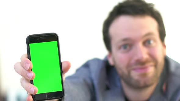 Businessman receiving good news on smartphone and showing it to the camera alt