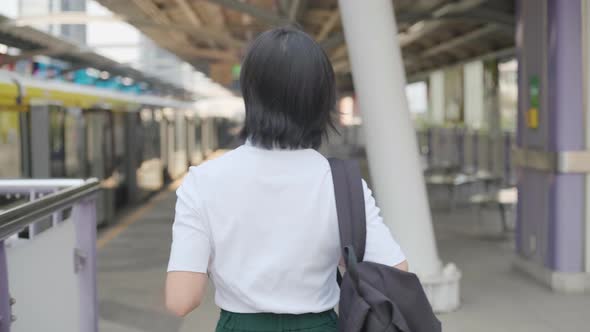 Portrait of asian woman with earphone listening music and using smartphone