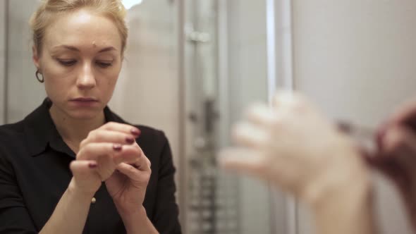 Handheld Shot of Woman Doing Make Up in the Bathroom alt