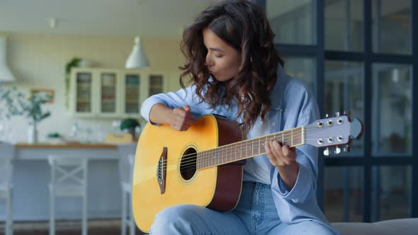 Girl Playing Guitar at Home. Happy Woman Practicing Music on String Instrument alt