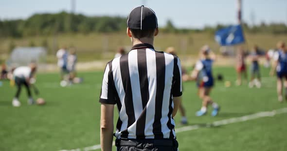 Female Sports Team Playing Rugby at the Stadium. Silhouette of the Referee Watching the Match. The alt
