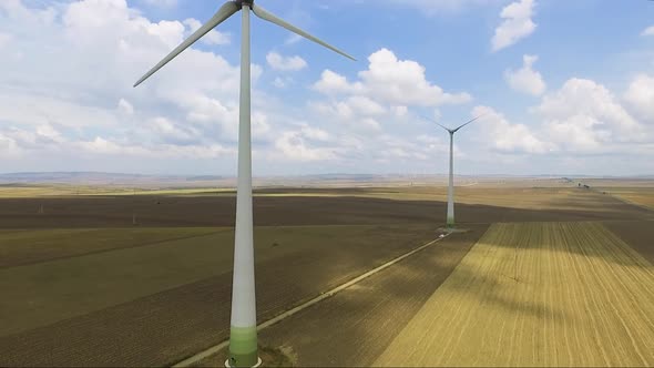 Aerial shot of power generating windmills over agricultural fields