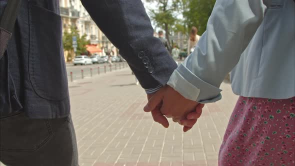 the Hands of a Couple in Love Walk Through the Spring City