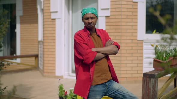 Confident African American Young Man Crossing Hands Looking at Camera Standing Outdoors on Summer alt