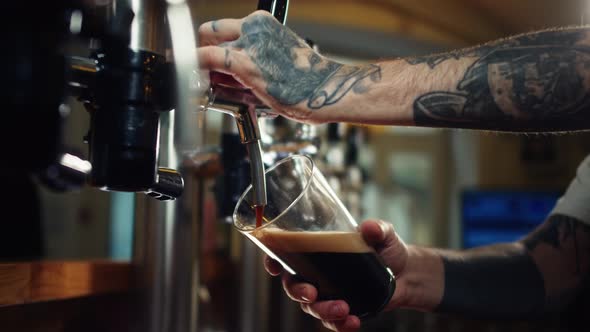 Barman Pouring Nitrogen Beer Into Glass Closeup alt