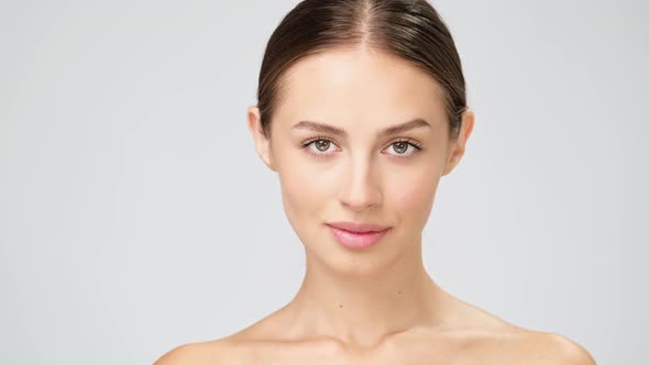 Beautiful Young Woman with Clean Fresh Skin Standing Over Light Grey Background alt