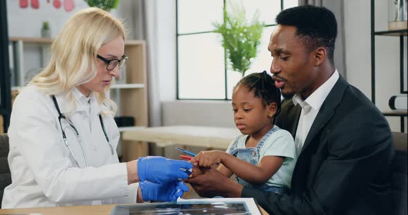 Pediatrician Applying Pulse Oximeter to Cute African American 6-Aged Girl to Check Blood Oxigen alt