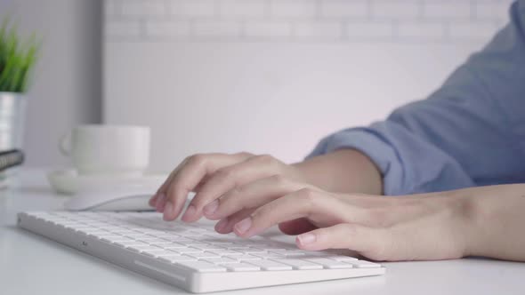 young smiling Asian woman working on laptop while at home in office work space. alt