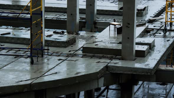 Construction site in the rain. High rise building construction. Foundation, floors, concrete piers