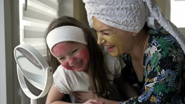 Young Woman with Her Daughter 67 Years Old Applied Cosmetic Masks To Their Faces alt