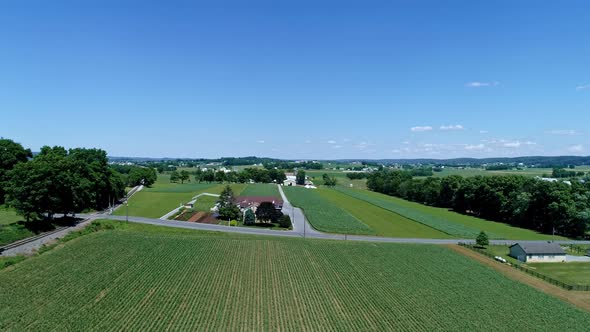 Aerial View of the Farm Countryside With Planted Fields and a Single Rail Road Track alt