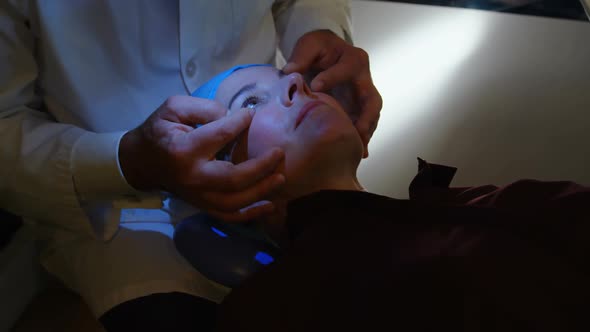 Optometrist examining patient eyes in clinic 4k alt