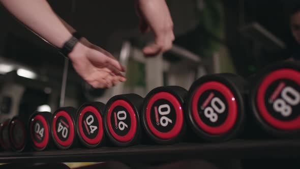 Close up of hands choosing weights alt