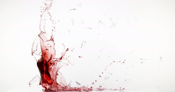 Glass of Red Wine Breaking and Splashing against White Background, Slow motion 4K