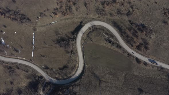 Descending on curvy road while car is passing 4K drone video alt