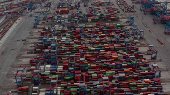 Aerial View of Rows of Colorful Cargo Containers in Large Industrial Port Being Moved By Automated alt