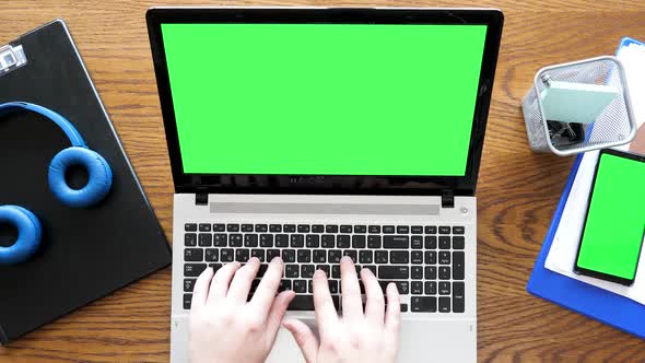 Man Hands Typing on a Laptop with Green Screen Then Touching a Green Screen Display on a Smartphone alt