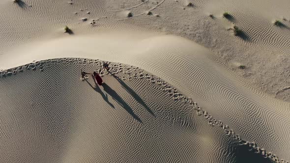 Top View on Three Women Dancing in the Middle of the Desert in the Morning alt