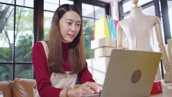 Asian female shop owner working online happy for new customer order